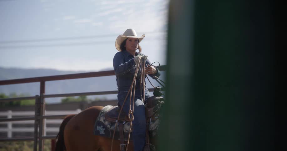 A woman riding a horse holding a rope