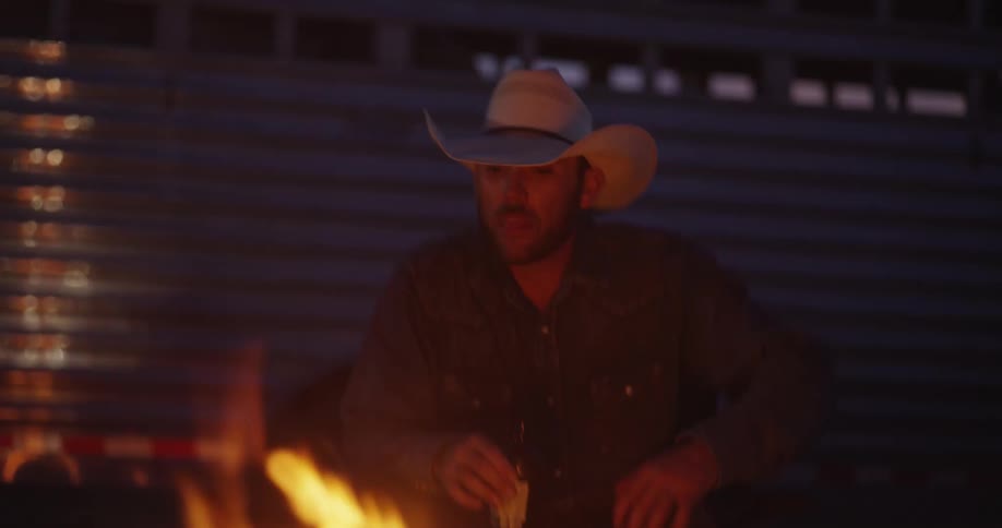 A cowboy spits into the fire
