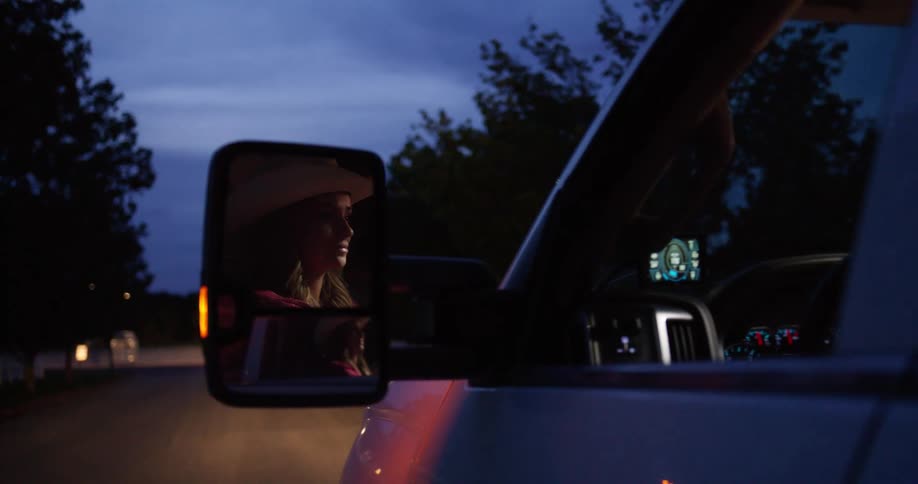 A female riding a vehicle in the evening on a lonely road