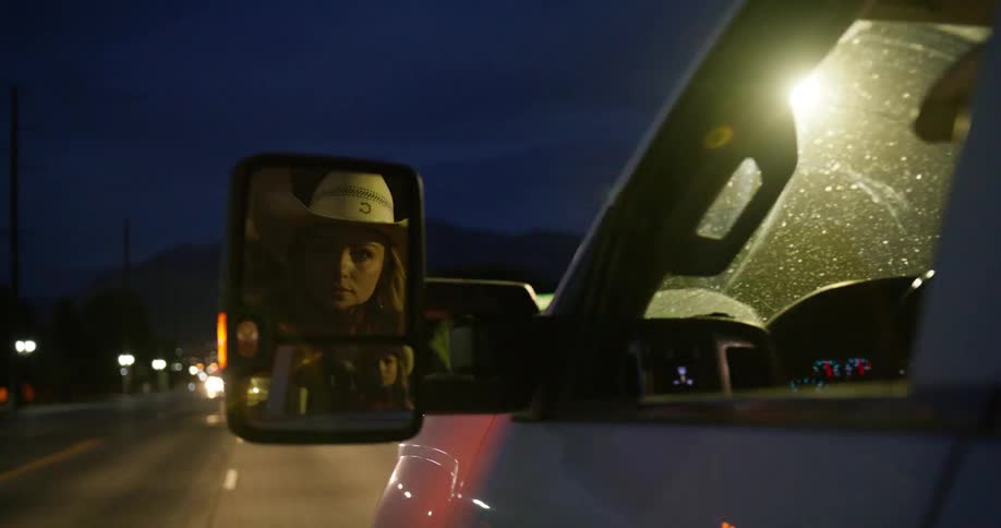 Woman driving a vehicle on a highway at night