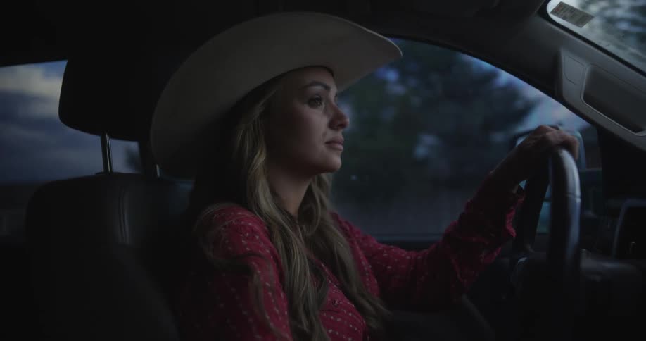 Portrait of a cowgirl driving a car