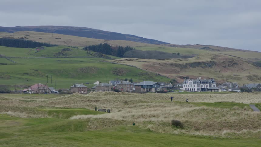 A small rural town with plains and mounts during the cloudy day