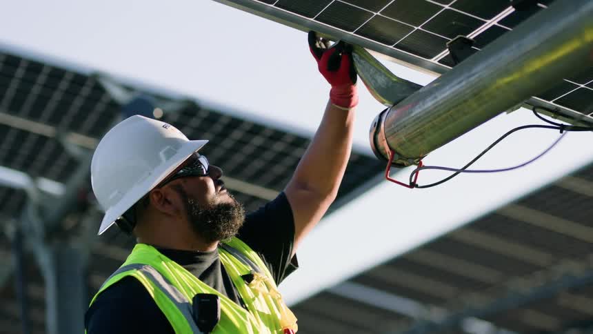 Construction worker repairing a solar panel