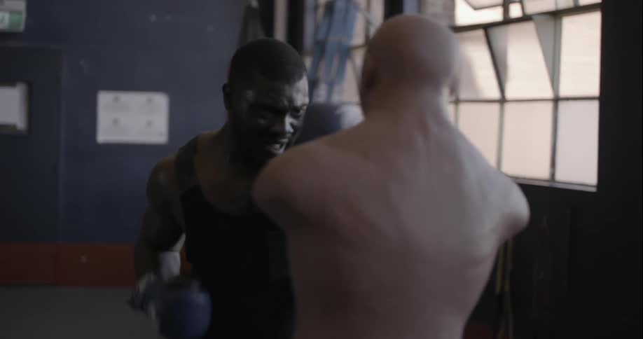A man walks up and boxes a dummy
