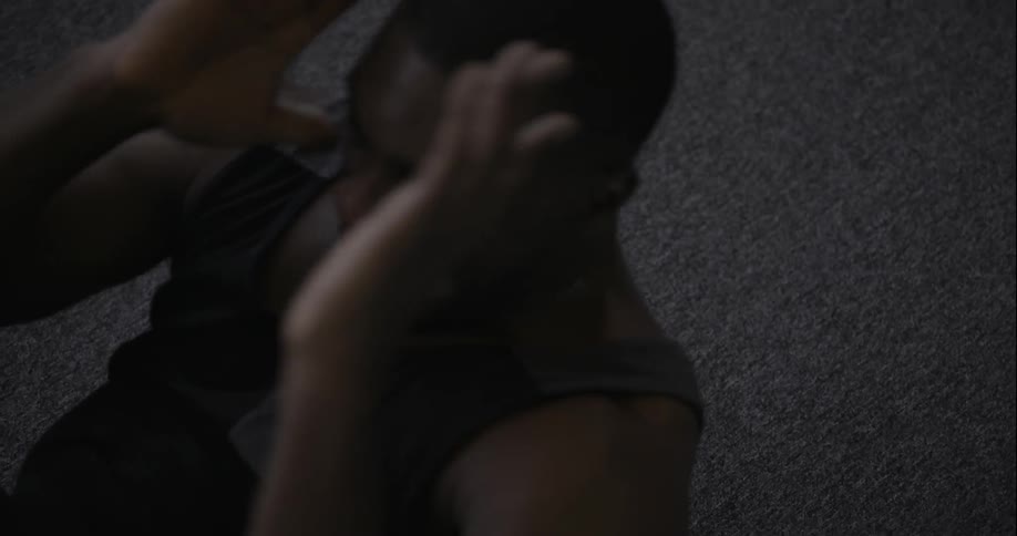 A man is laying on his back doing sit ups
