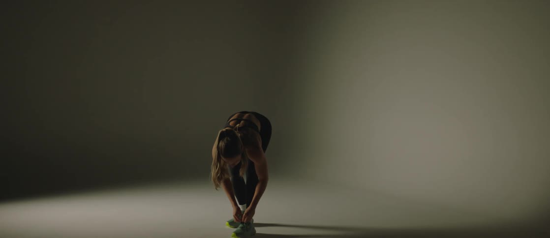 Woman tying her tennis shoes and then modeling in fitness clothes