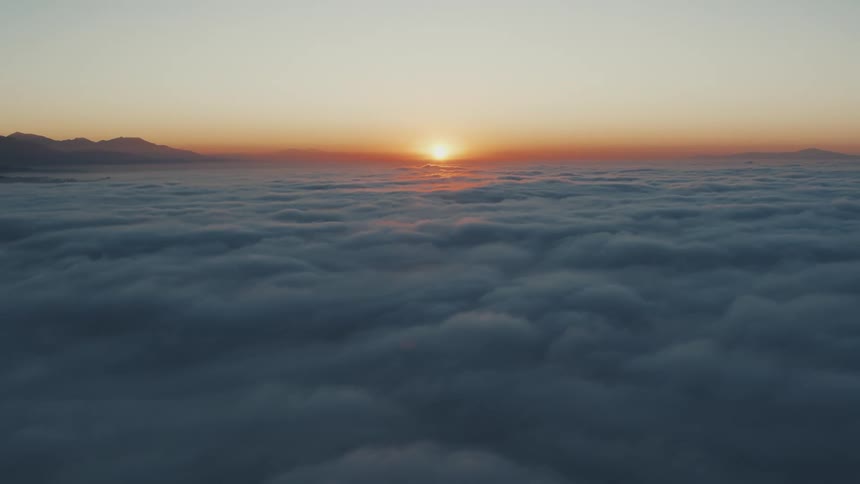 The sun rises above the sky