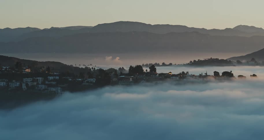 Aerial view of clouds over the suburbs in the hills at morning
