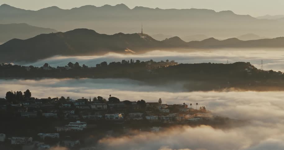Panoramic aerial shot of the Hollywood Hills neighborhood at cloud level under a morning sky