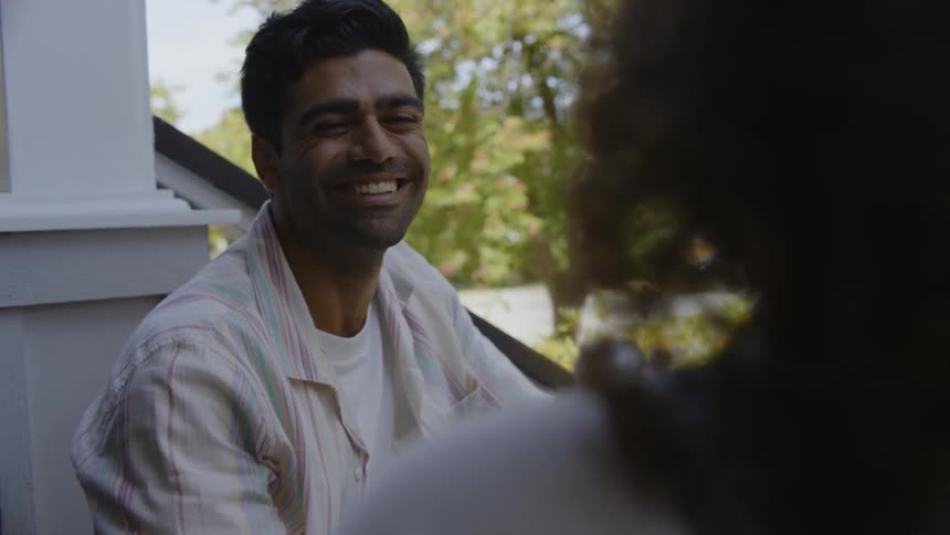 Man smiles while talking with a lady outdoor during the day