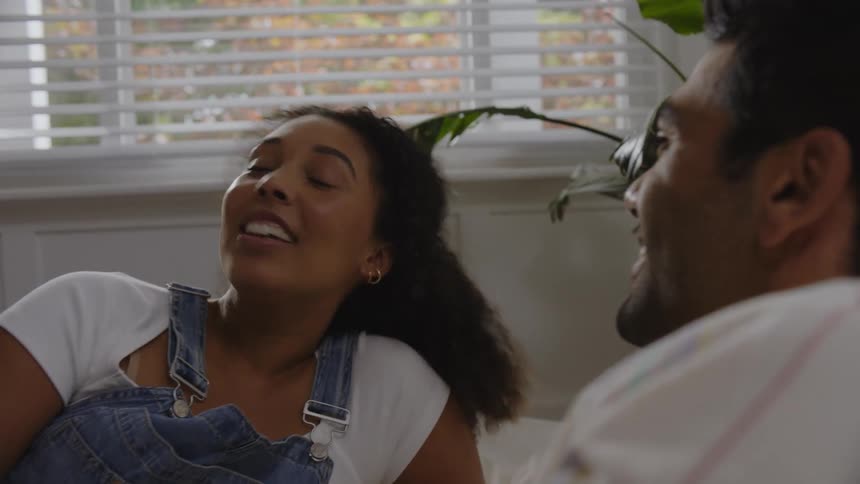 A man and a woman talking while lying in bed