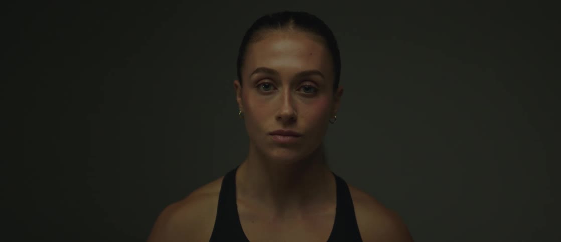 A face of a young woman who looks to the side and then looks forward and blinks