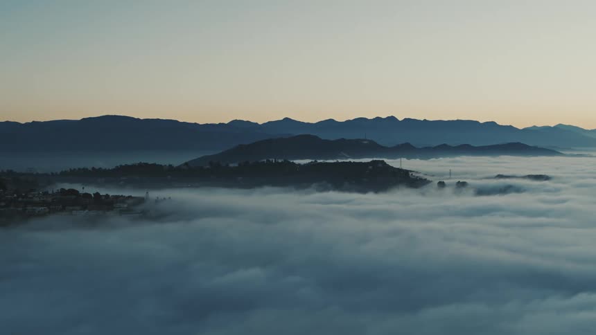 Aerial of mountains covered by clouds during dawn