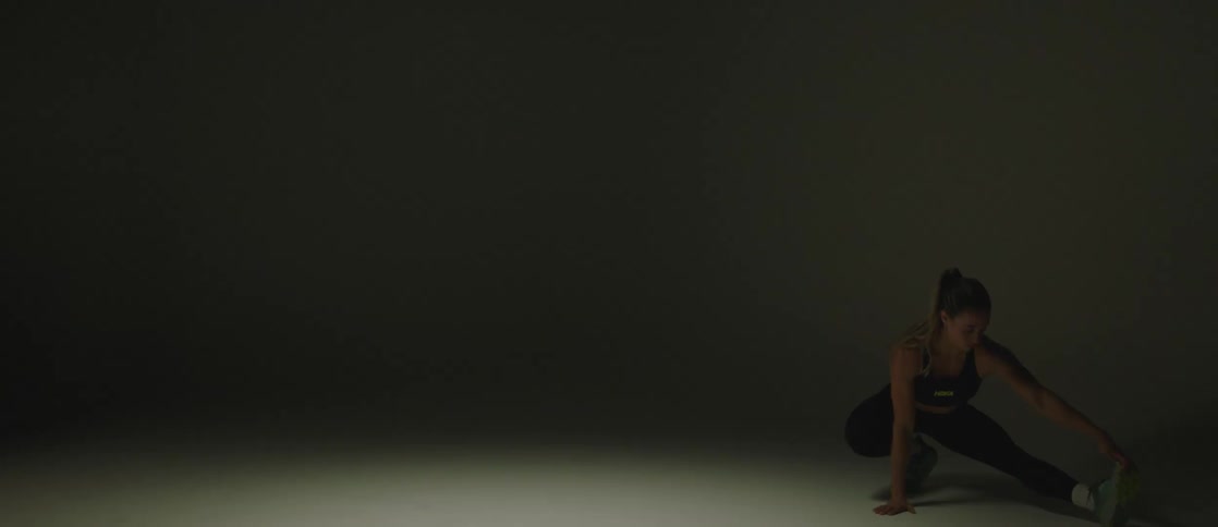 Young fit woman stretching on the floor of an empty room