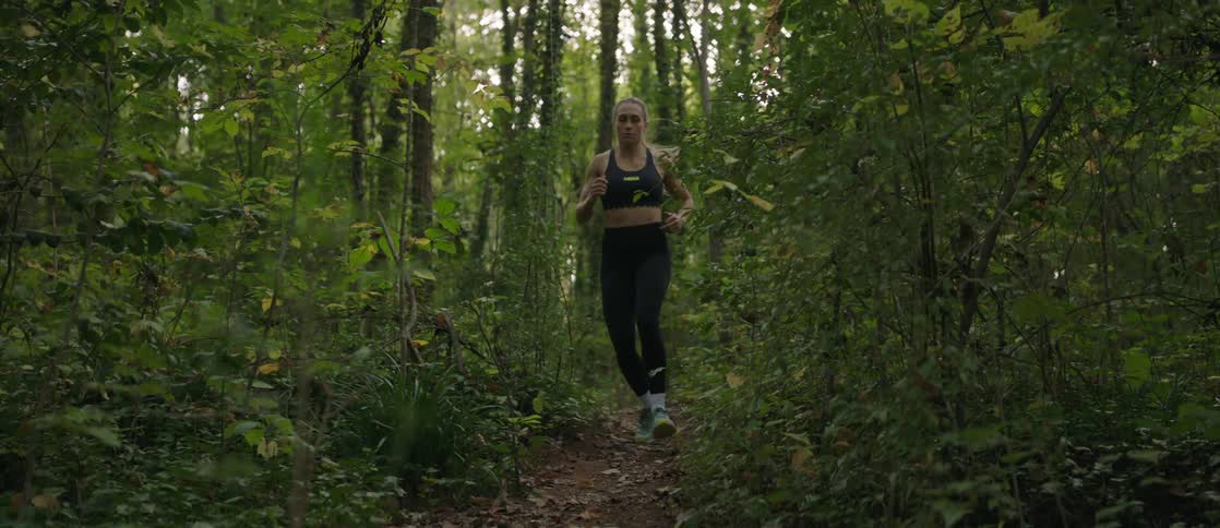 A woman running on a forest path