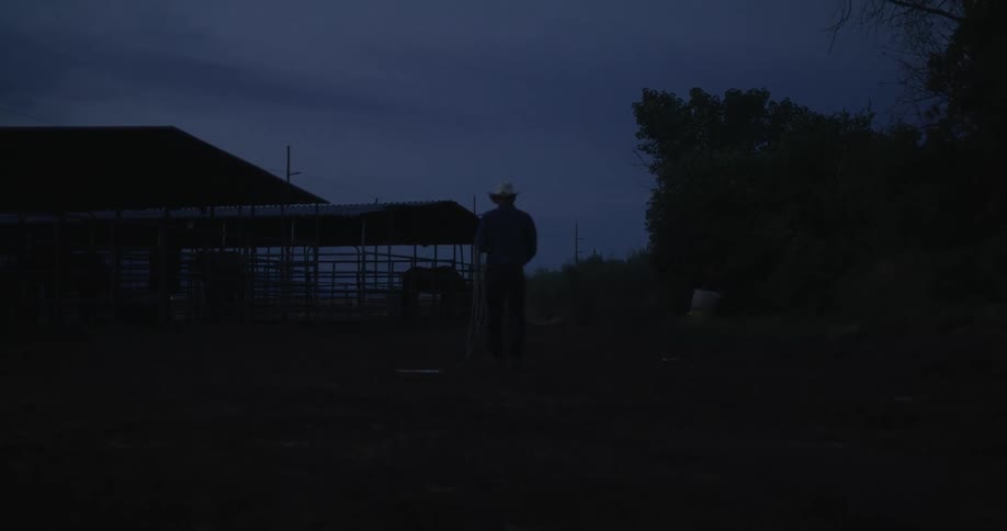 Cowboy walking on the ranch at dawn