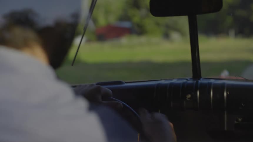 A man driving a pickup truck during the day