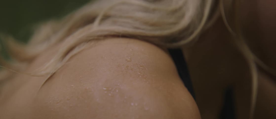 The shoulder of a blonde woman who is all sweaty