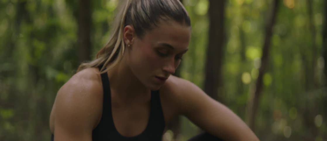 A woman resting in the forest after running