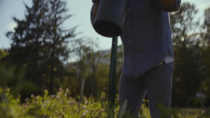 A farmer builds fence in the field on his farm at daytime