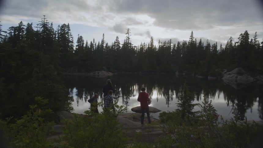 Children running towards the shore of a lake