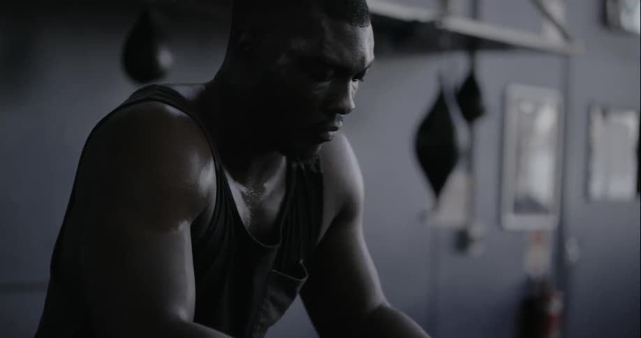 Man sitting in a gym rubbing his hands together