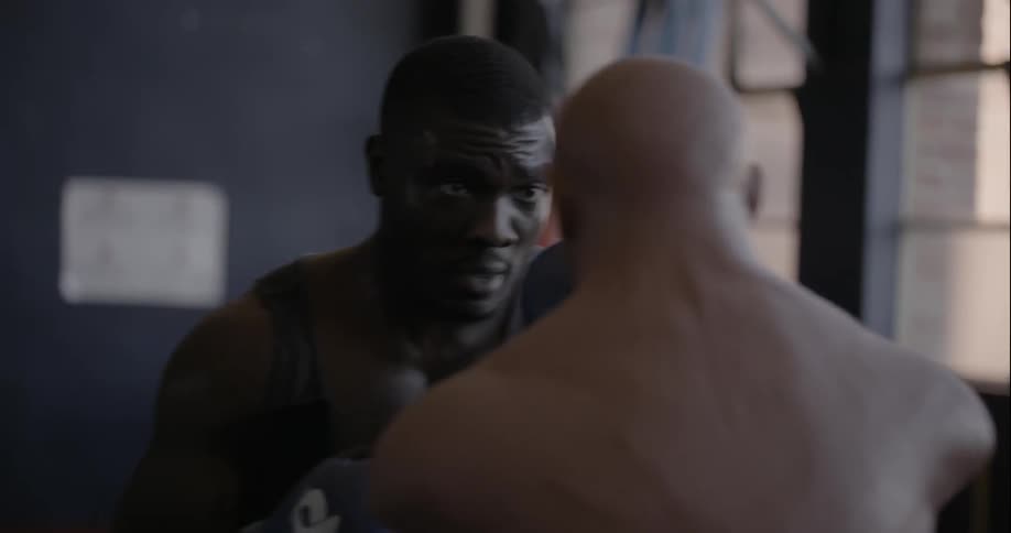 A man is boxing with a dummy