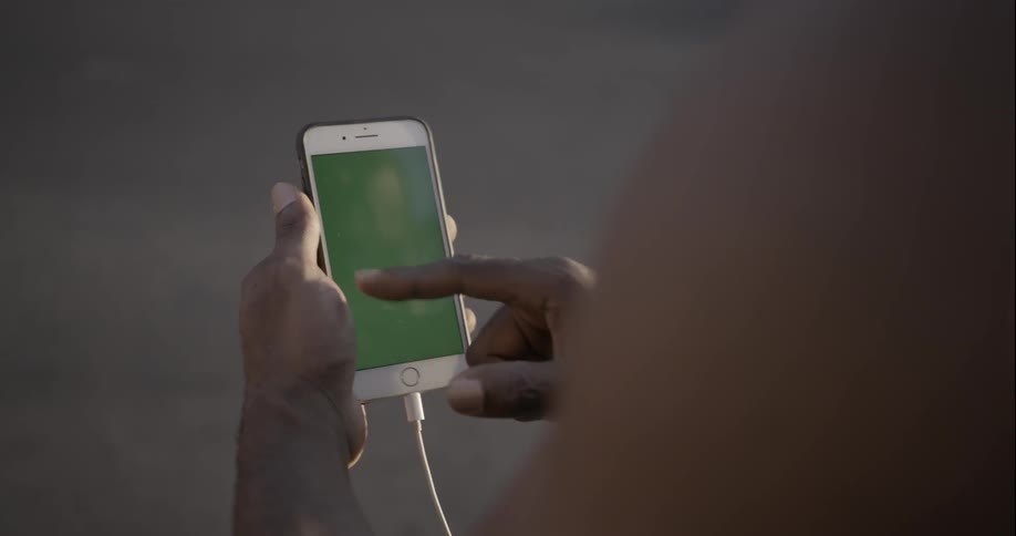 A person is using a phone on a sunny day