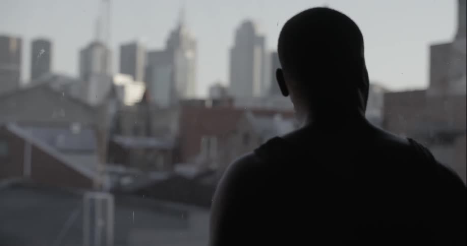 A man looks over a city from a window