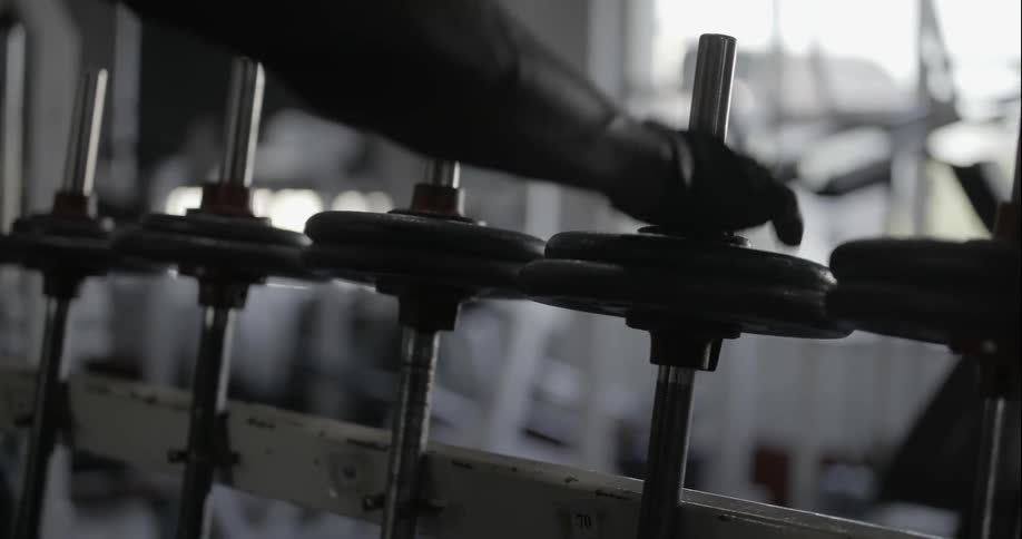 Man choosing a barbell to work with