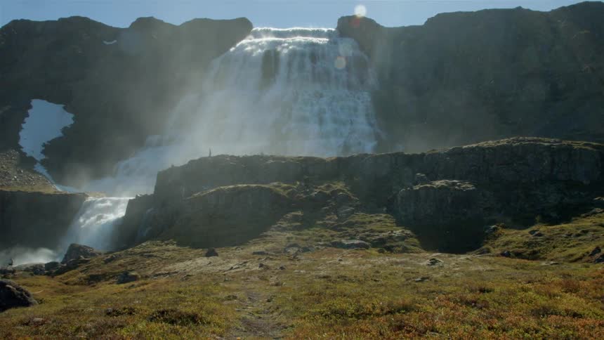 A waterfall pours into a stream ahead
