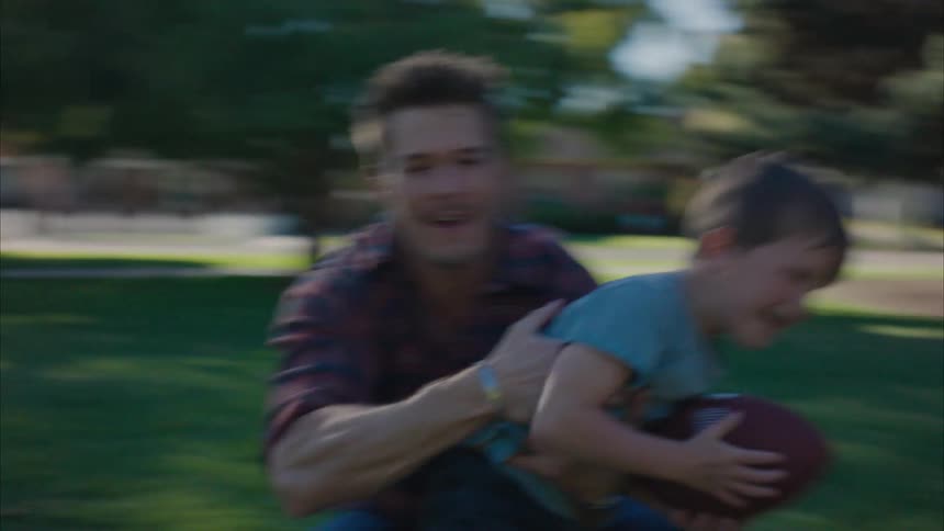 Father playing football with his son in the park