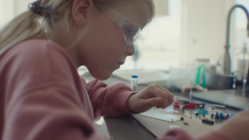 Girl holding a soldering pen and analyzing a software device