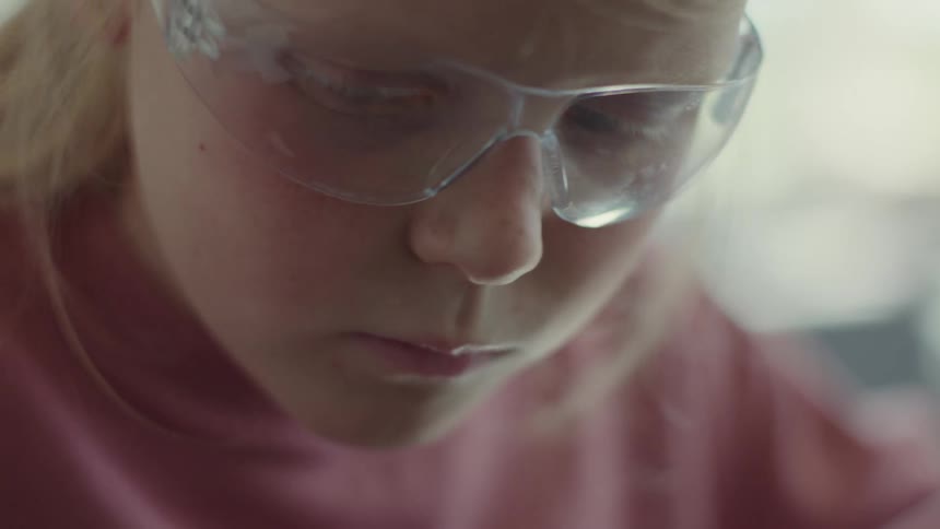 A face of a little blonde girl wearing transparent glasses