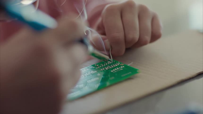 An electrician soldering an electrical component