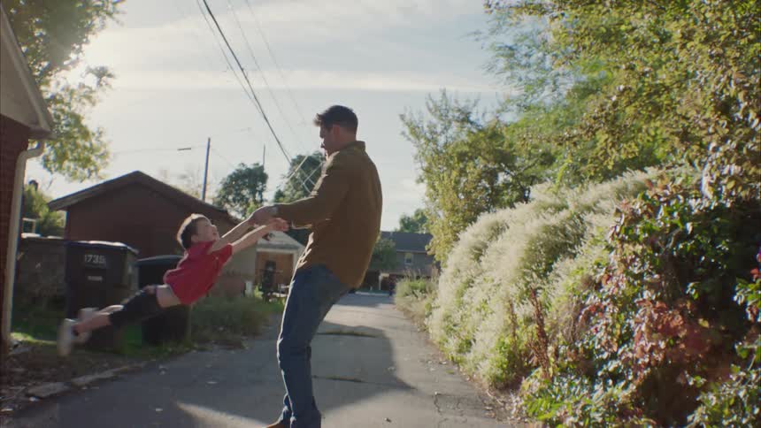 A father playing spin with his little son