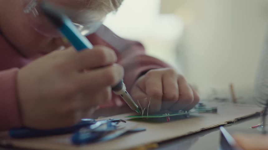 Girl soldering copper onto a device