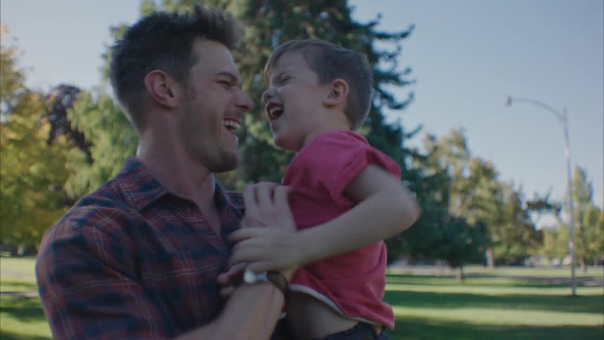 Father tickling son at the park