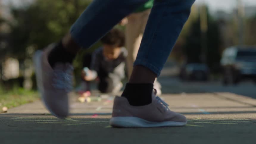 Boys playing hopscotch on the suburb sidewalk