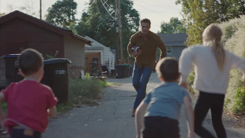 A father plays football with his children
