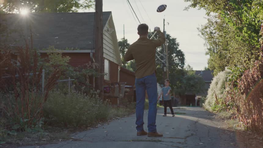 Father playing football with his son in the yard