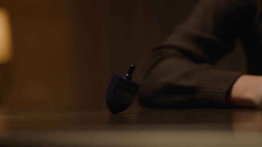 Two people spin a dreidel on the table