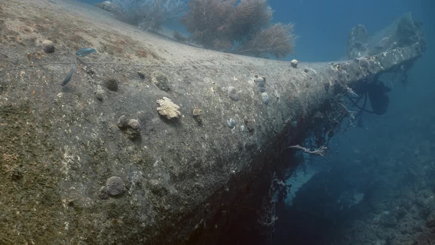 The wreckage of a very old and deteriorated boat sits on the ocean floor