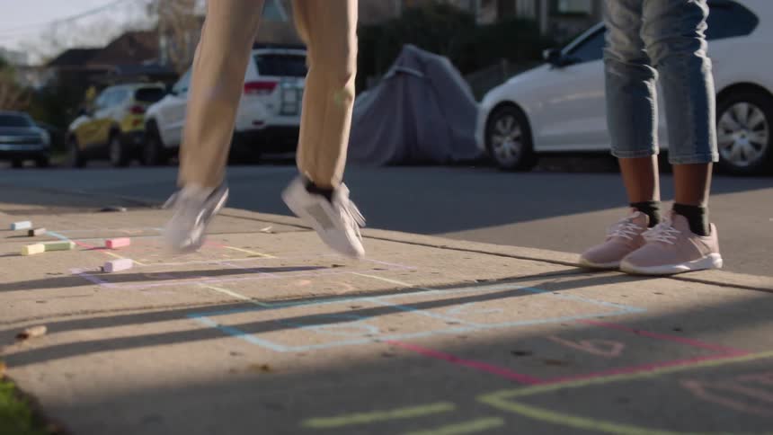 Children jumping on a sidewalk and playing