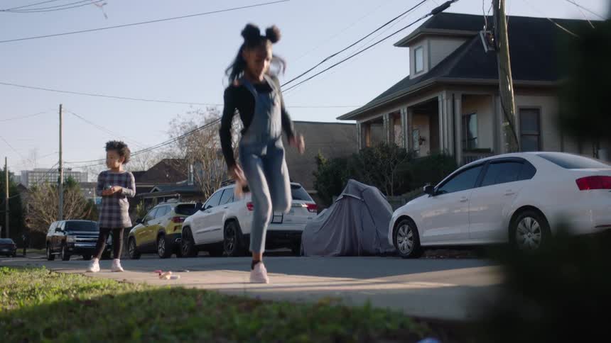 Children playing and jumping on a sidewalk