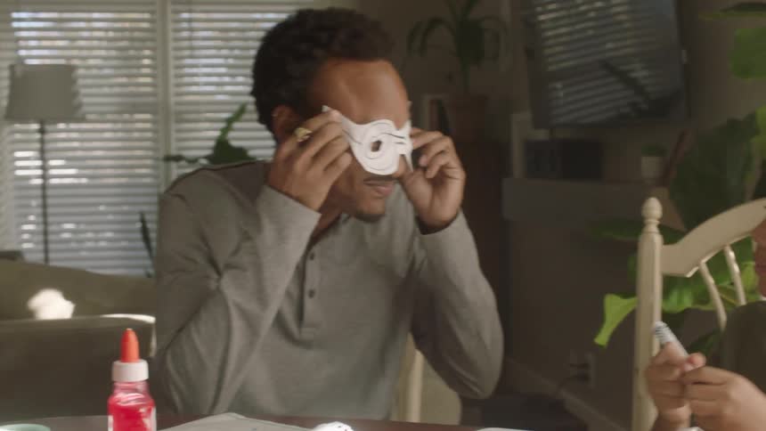 Father has fun with his children while doing homework