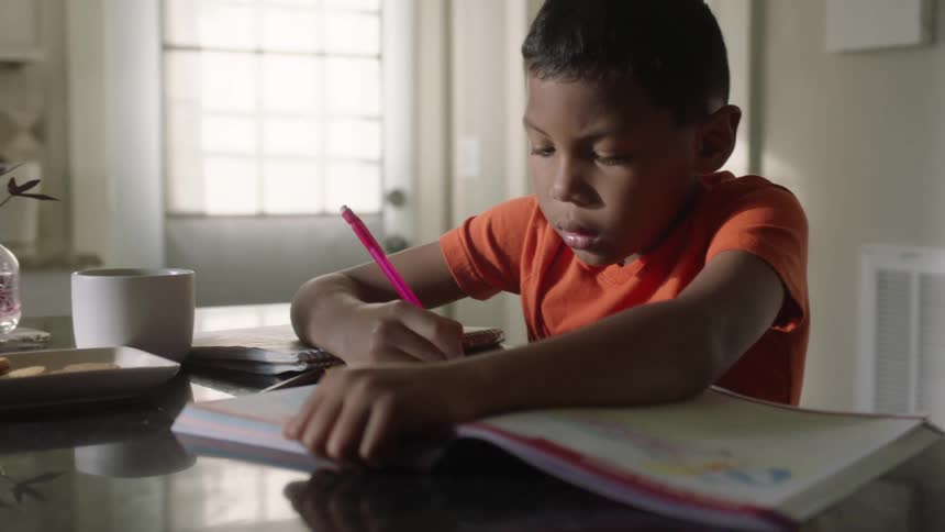Kid doing homework in the kitchen