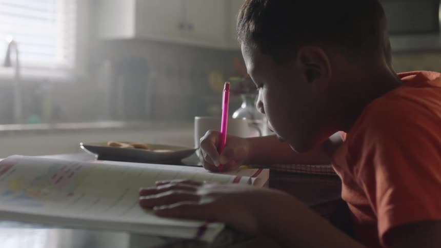 Boy doing homework in the kitchen
