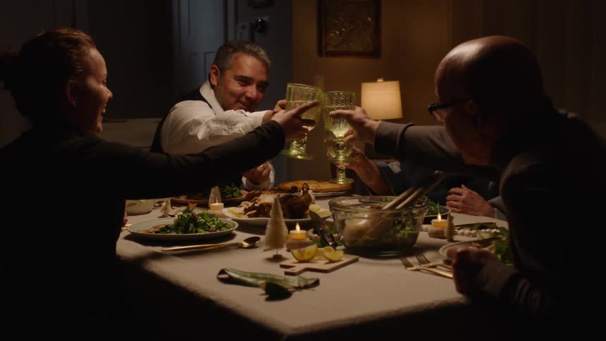 Men and women seated at the dinner table made a toast with drinks