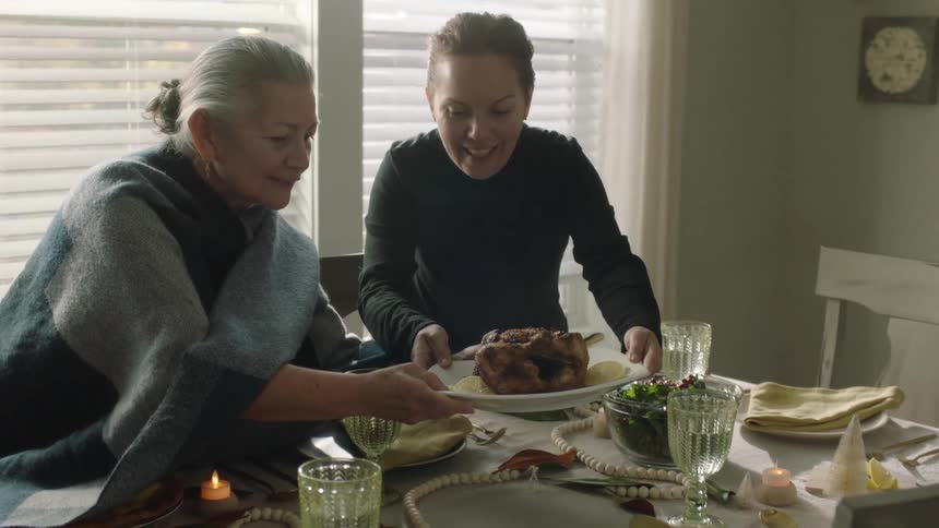 Mother and daughter setting a dining table